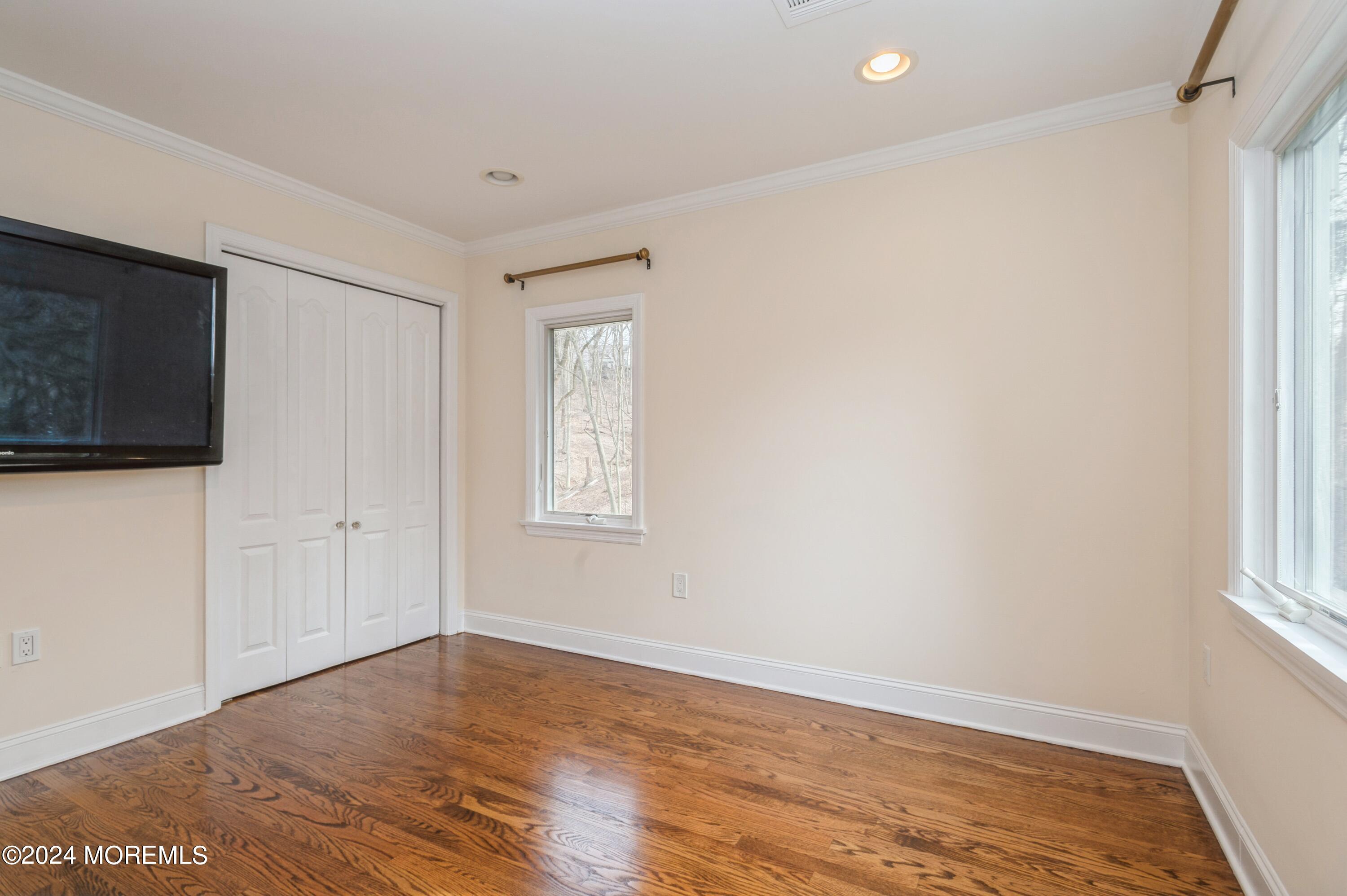 26 Van Brackle Road Holmdel, NJ 07733 - Photo 17 of 36 a view of empty room with wooden floor and fan