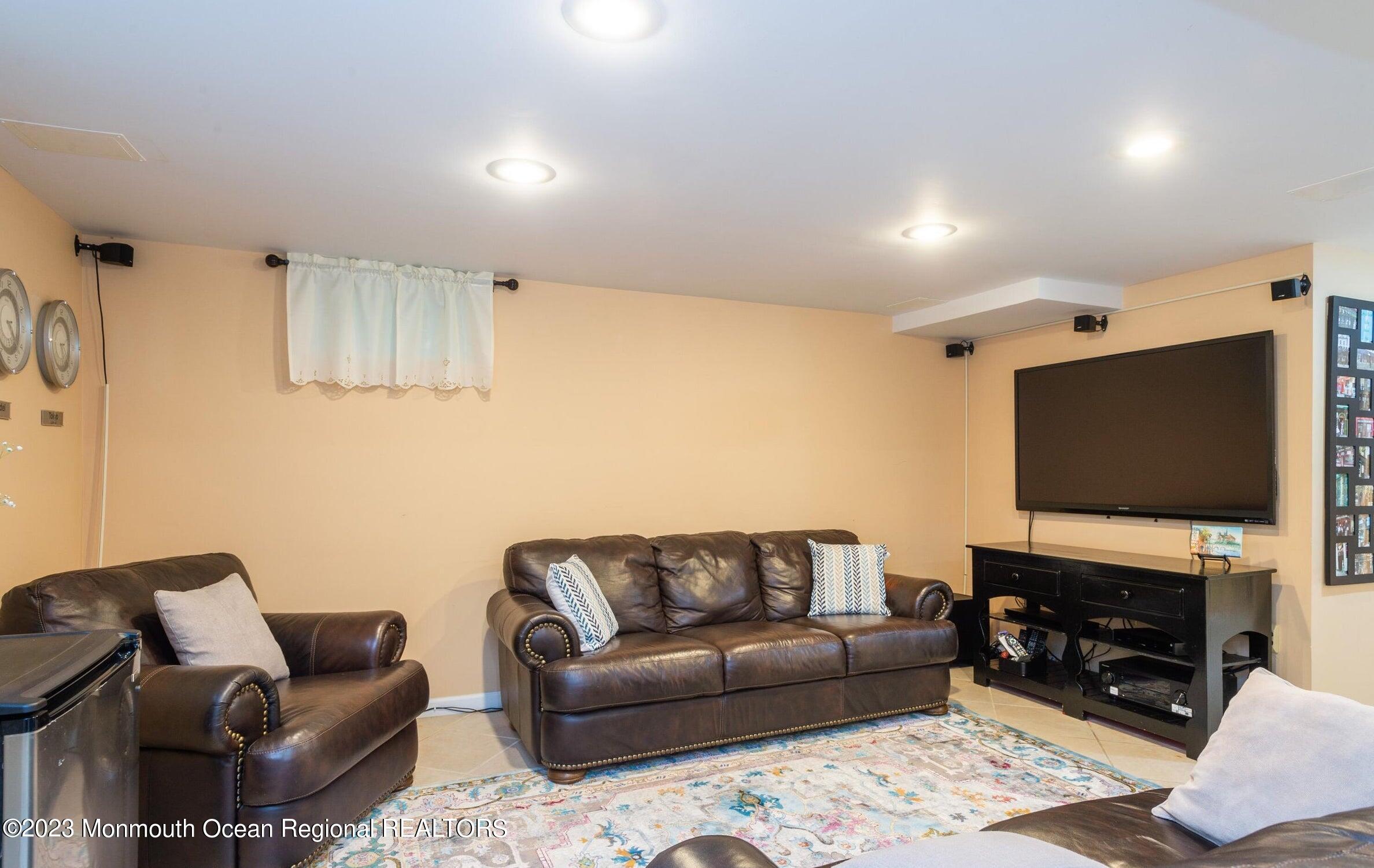 26 Van Brackle Road Holmdel, NJ 07733 - Photo 26 of 36 a living room with furniture and a flat screen tv