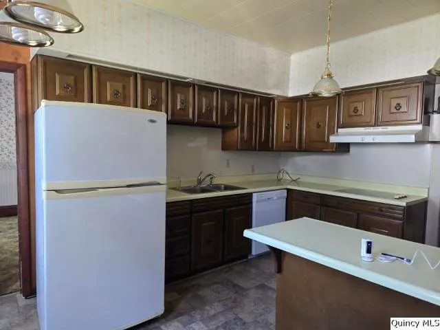 a kitchen with a refrigerator sink and cabinets