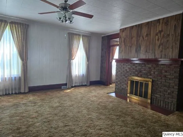 an empty room with windows and fireplace