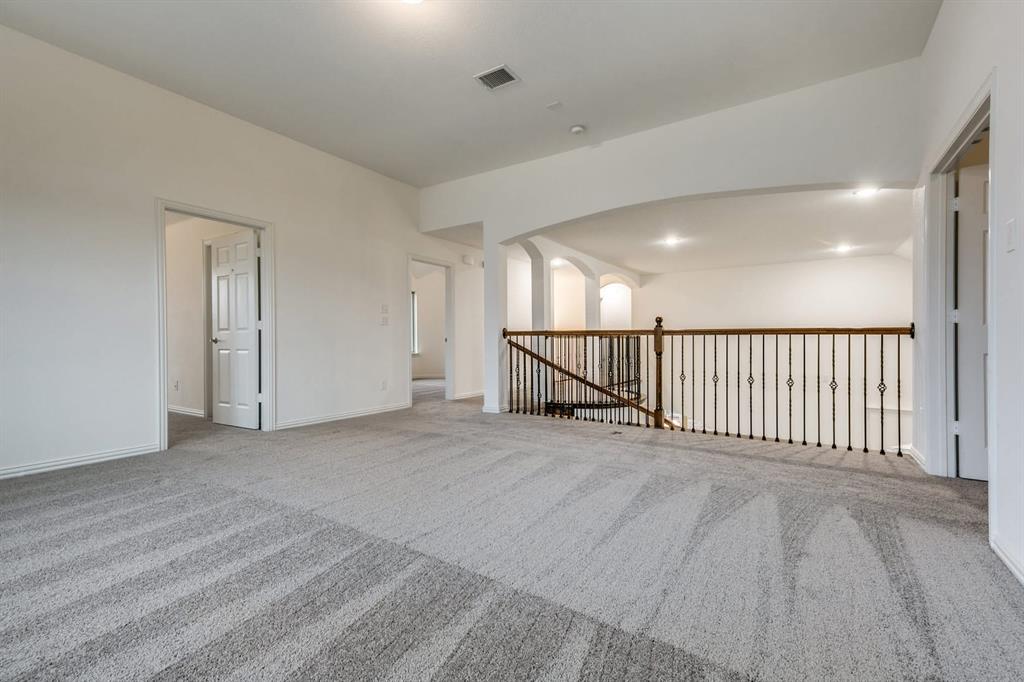 104 Sweetleaf Drive Red Oak, TX 75154 - Photo 29 of 36 Spacious carpeted area featuring a railing with decorative metal spindles, white walls, and recessed lighting