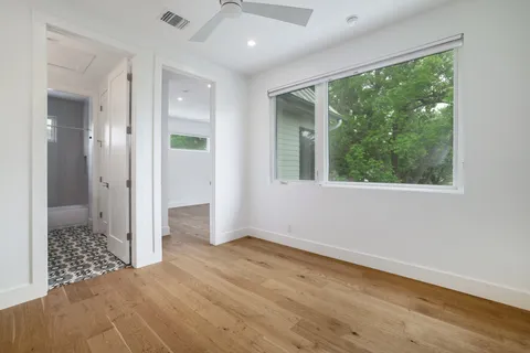 an empty room with large windows and a bed