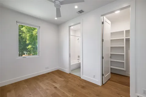 a view of an empty room with a window and closet area