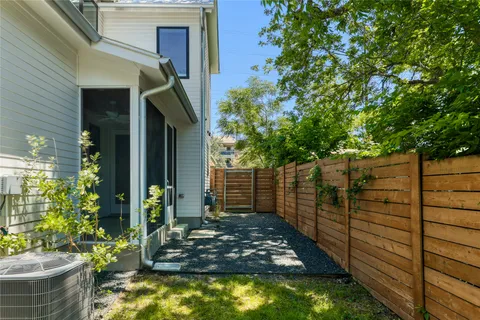 a view of a house with a small yard and wooden floor and fence