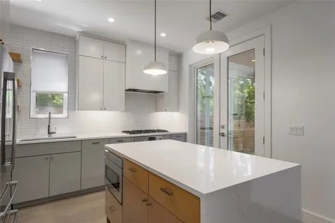 a kitchen with a sink a center island and cabinets