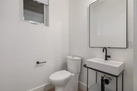 a bathroom with a toilet a sink and mirror