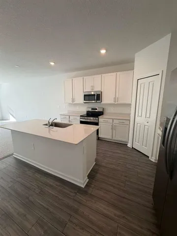 a kitchen with wooden floors and white appliances