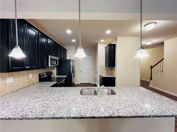 a kitchen with granite countertop stainless steel appliances and wooden cabinets