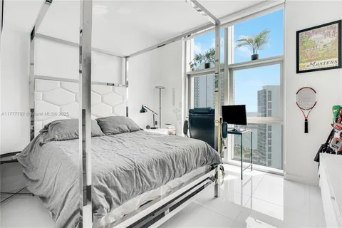 a bedroom with a bed and a flat tv screen on the dresser