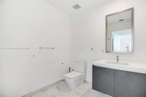 a bathroom with a toilet sink a mirror and vanity