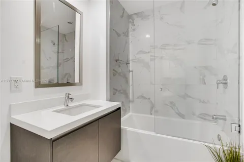 a bathroom with a sink vanity tub and shower