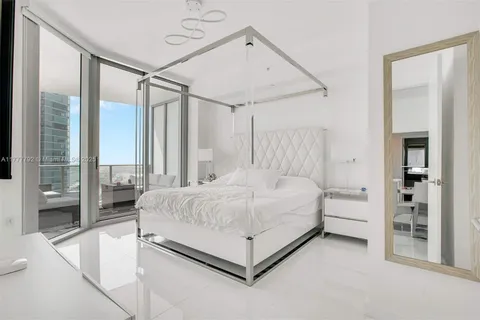 a spacious bedroom with a bed and a large mirror