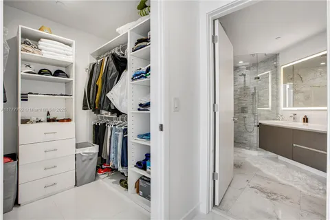 a view of walk in closet with clothes and shoes