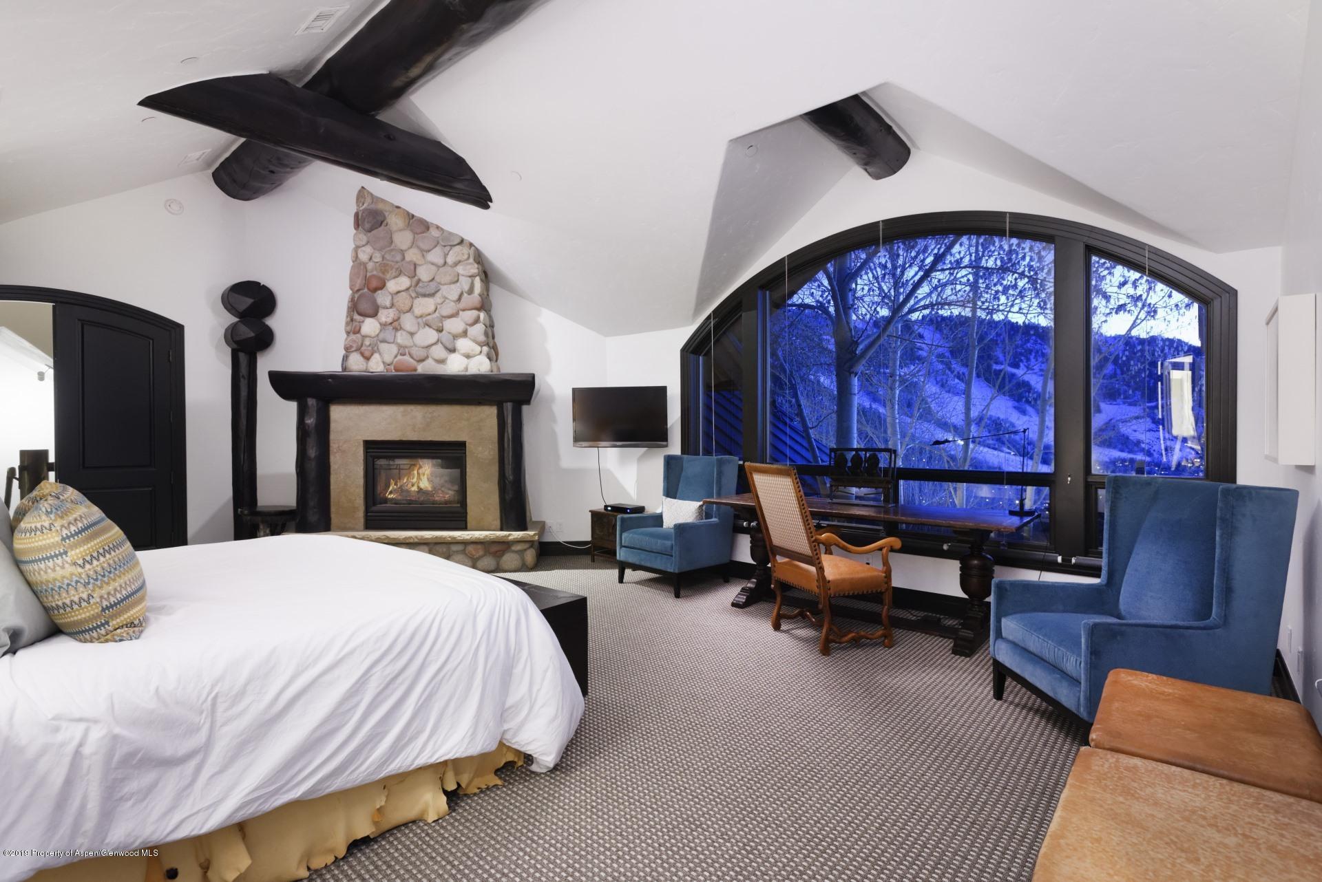 450 Smuggler Mountain Road Aspen, CO 81611 - Photo 12 of 37 a bedroom with a bed and wooden floor