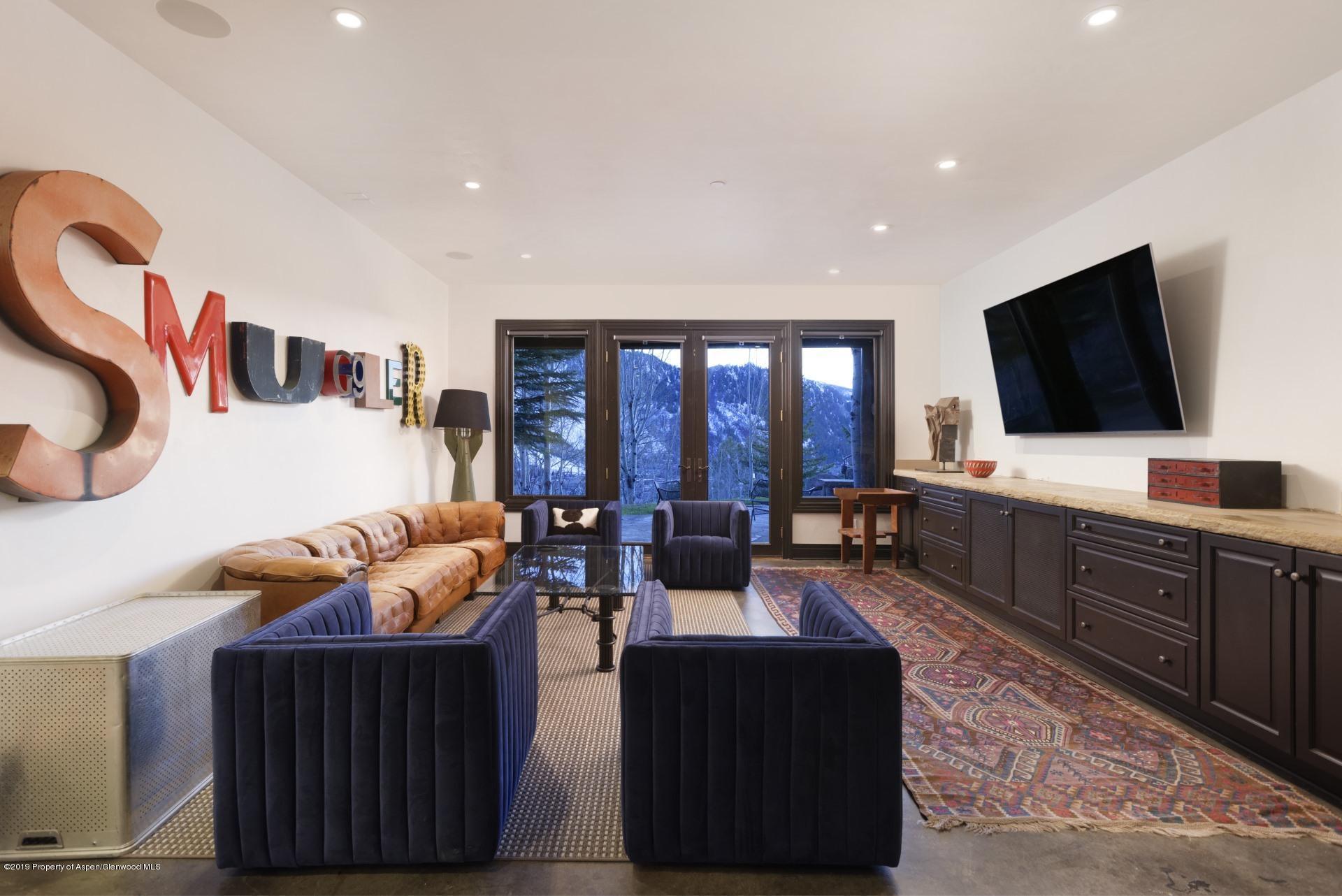 450 Smuggler Mountain Road Aspen, CO 81611 - Photo 14 of 37 a living room with furniture and a flat screen tv