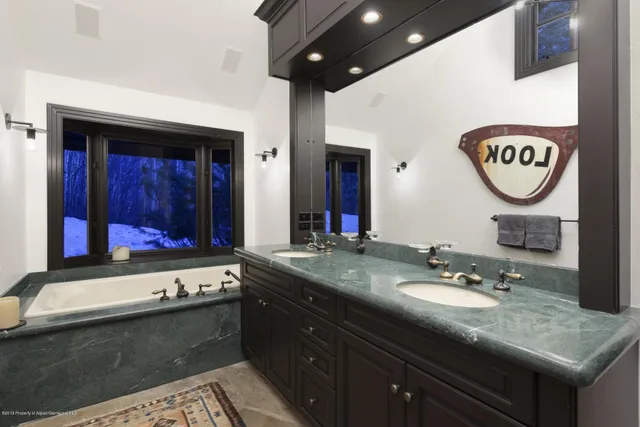 a bathroom with a sink a vanity and a large mirror