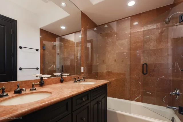 a bathroom with a double vanity sink mirror double and bathtub