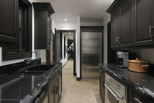 a kitchen with granite countertop a sink stove and refrigerator