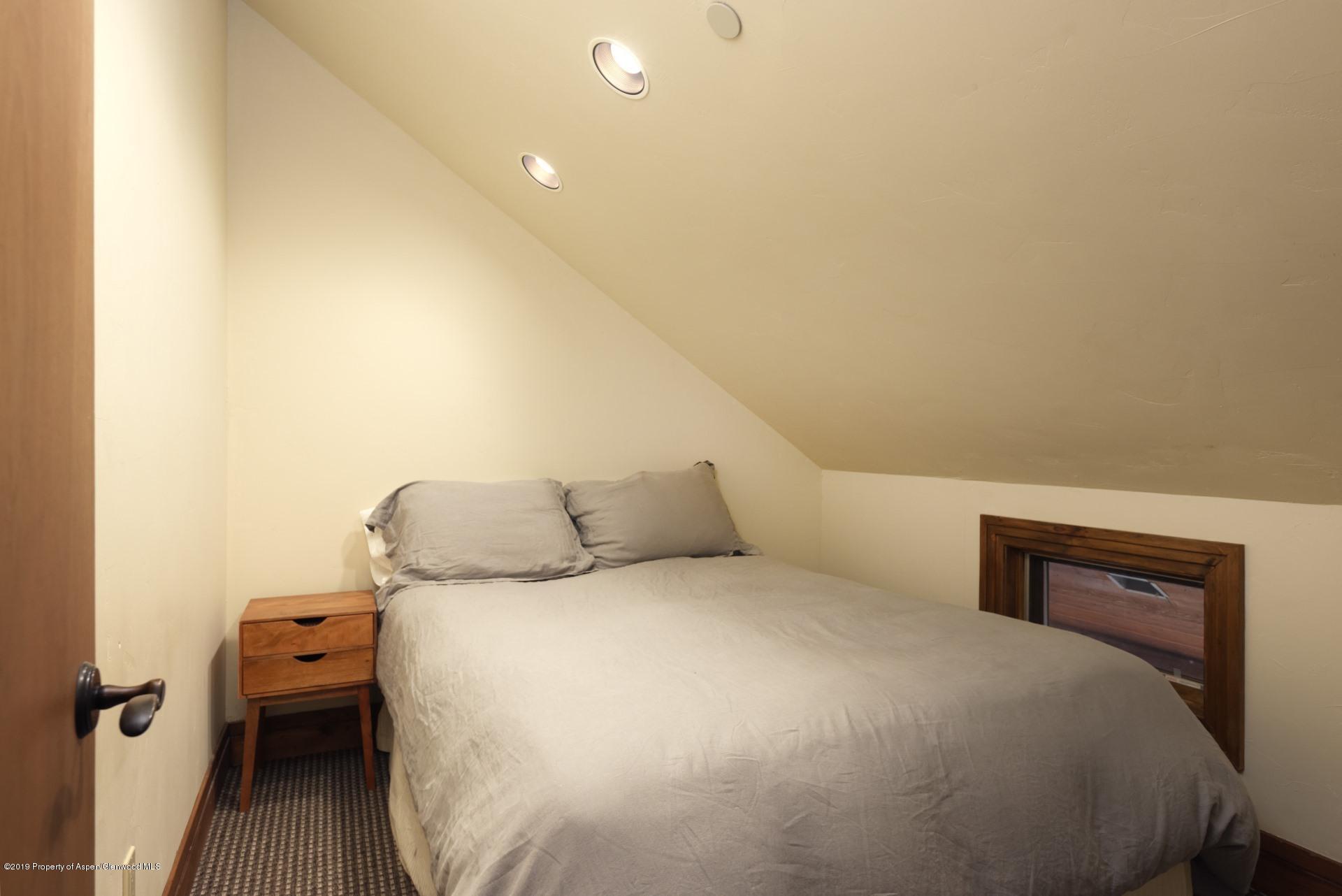 450 Smuggler Mountain Road Aspen, CO 81611 - Photo 30 of 37 a bedroom with a bed and wooden floor