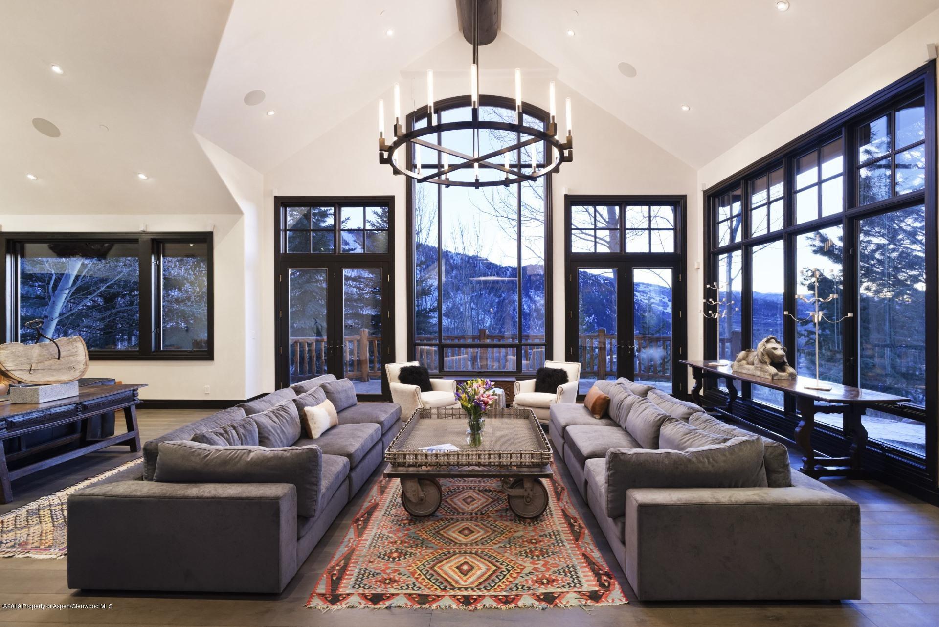 450 Smuggler Mountain Road Aspen, CO 81611 - Photo 3 of 37 a living room with furniture and floor to ceiling windows