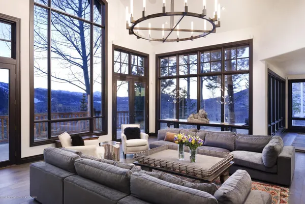 a dining room with furniture a chandelier and a floor to ceiling window
