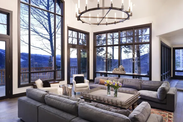 a dining room with furniture a chandelier and a floor to ceiling window