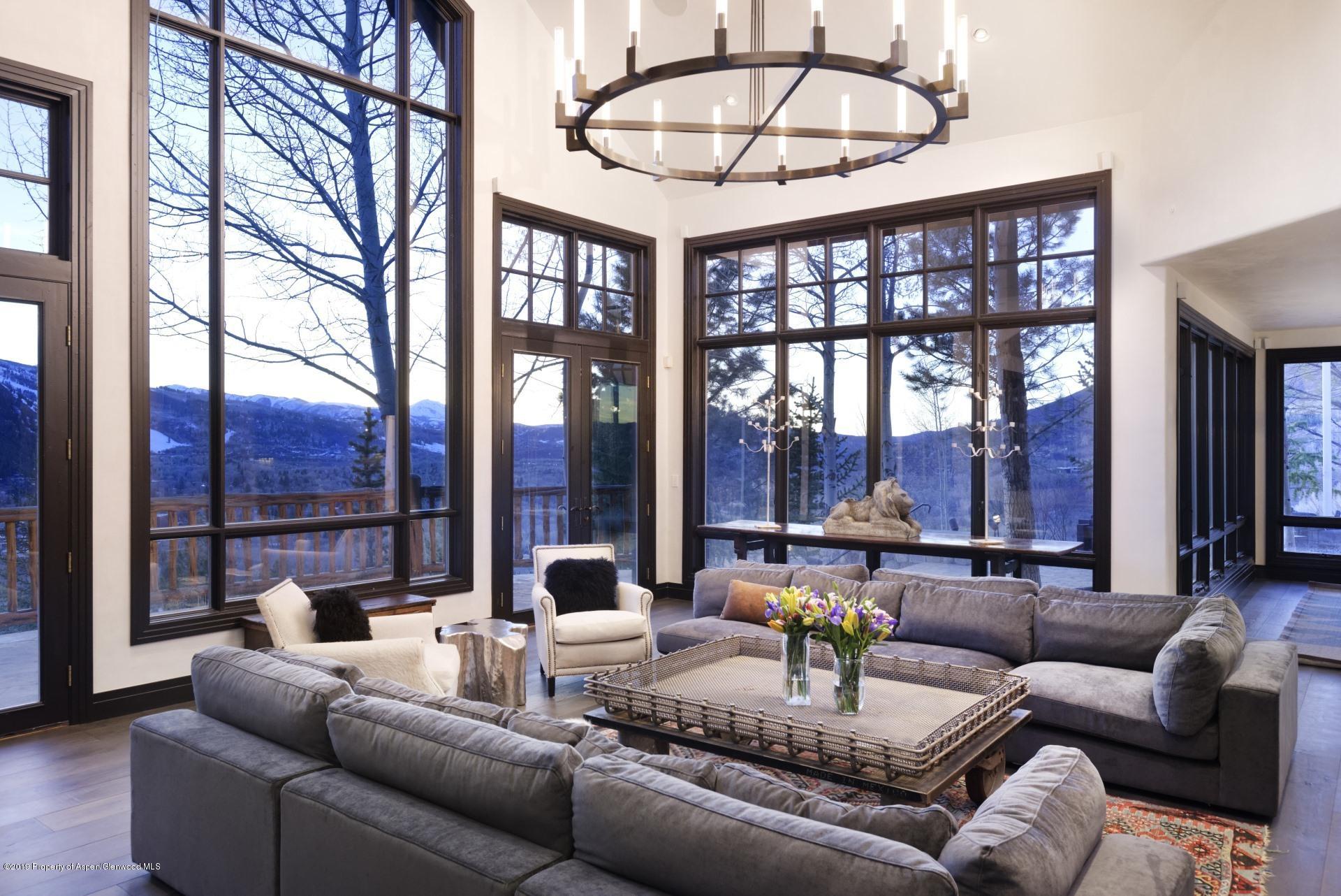 450 Smuggler Mountain Road Aspen, CO 81611 - Photo 4 of 37 a dining room with furniture a chandelier and a floor to ceiling window