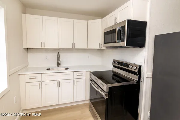 a kitchen with stainless steel appliances a sink stove and microwave