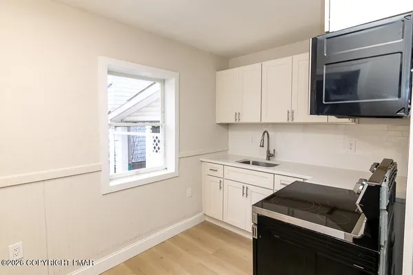 a kitchen with a sink stove and microwave