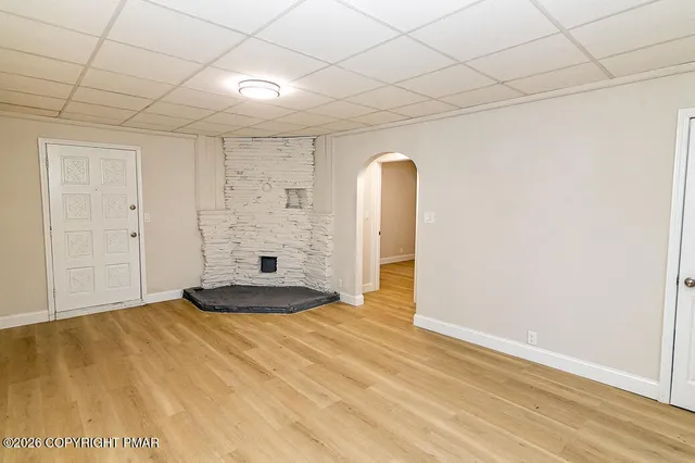 a view of a room with a wooden floor and white wall