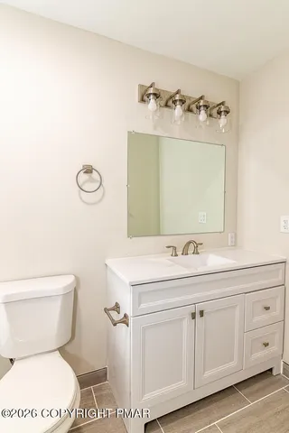 a bathroom with a sink a toilet and mirror