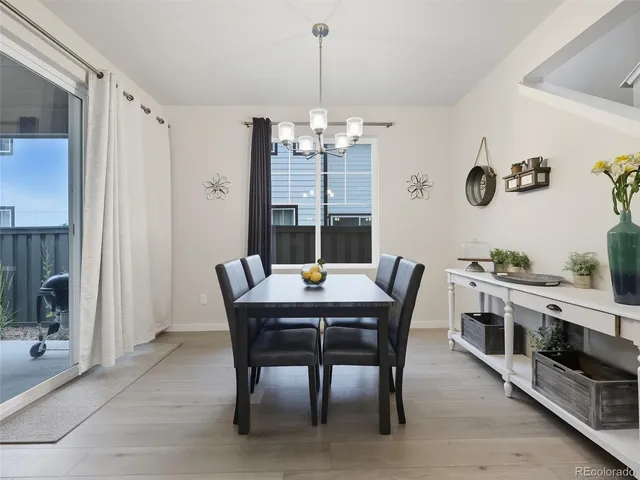 a dining room with furniture a chandelier and wooden floor
