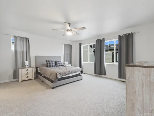 a spacious bedroom with a bed and a chandelier
