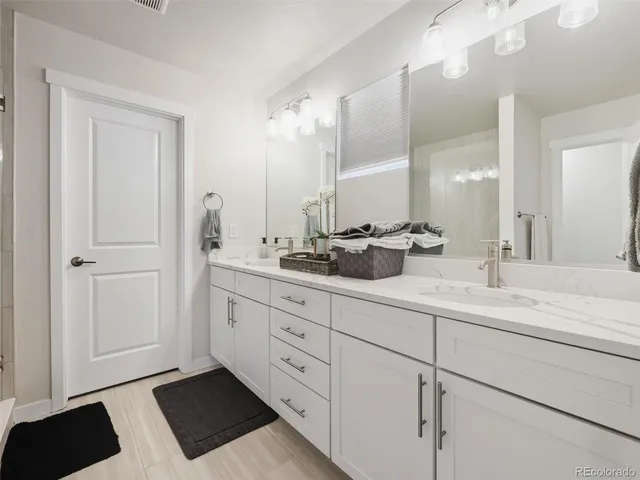 a bathroom with double sink and a mirror