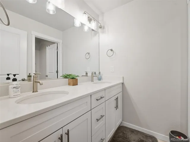 a bathroom with a double vanity sink and a mirror
