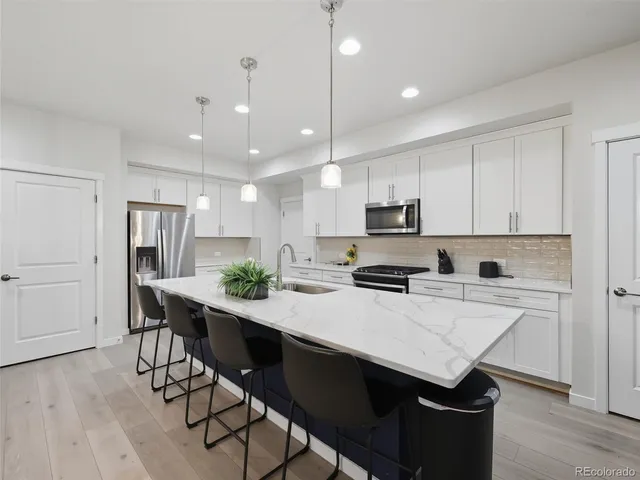 a kitchen with a dining table chairs refrigerator and microwave
