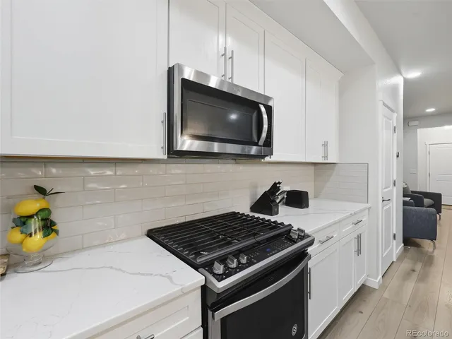 a kitchen with stainless steel appliances a stove microwave and sink