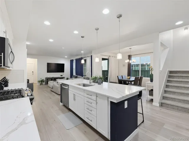 a large white kitchen with a large island in the center