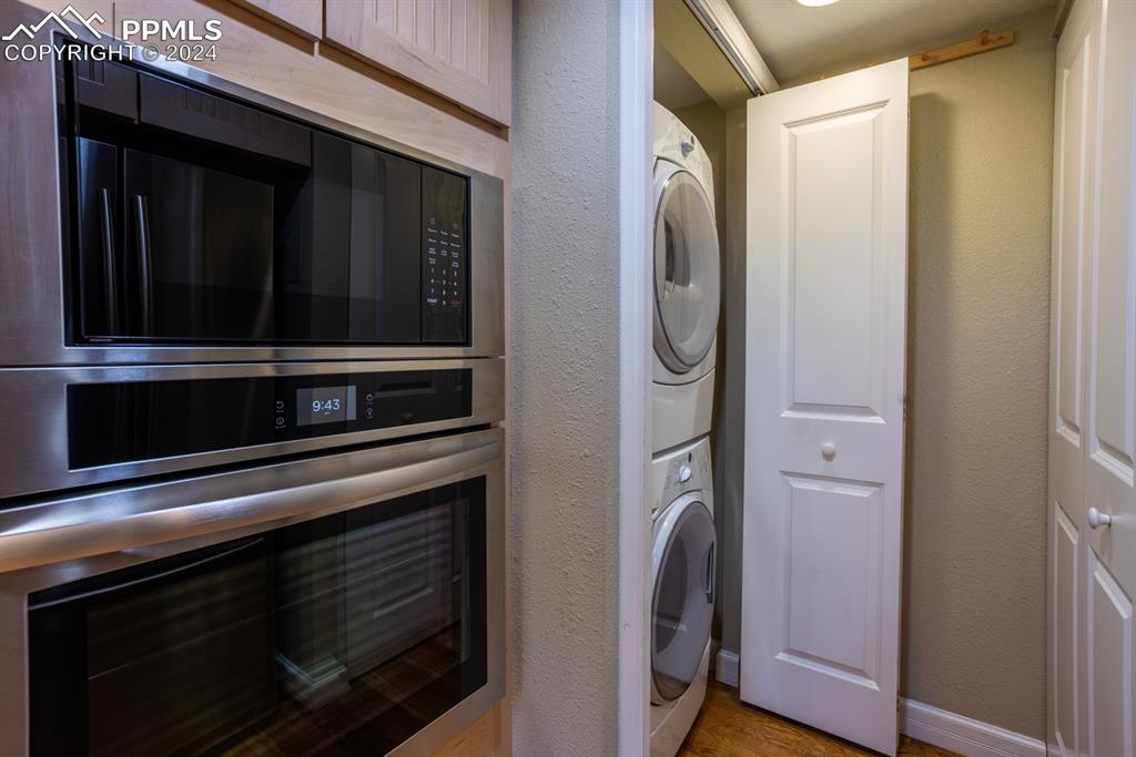1074 Fontmore Road, Unit C Colorado Springs, CO 80904 - Photo 11 of 30 Laundry adjacent to kitchen with light hardwood / wood-style floors and stacked washer / drying machine