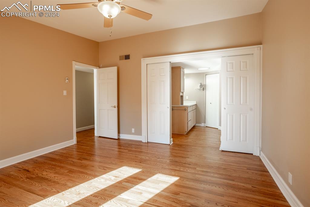 1074 Fontmore Road, Unit C Colorado Springs, CO 80904 - Photo 14 of 30 Primary bedroom featuring ceiling fan, light wood-type flooring, and ensuite bathroom