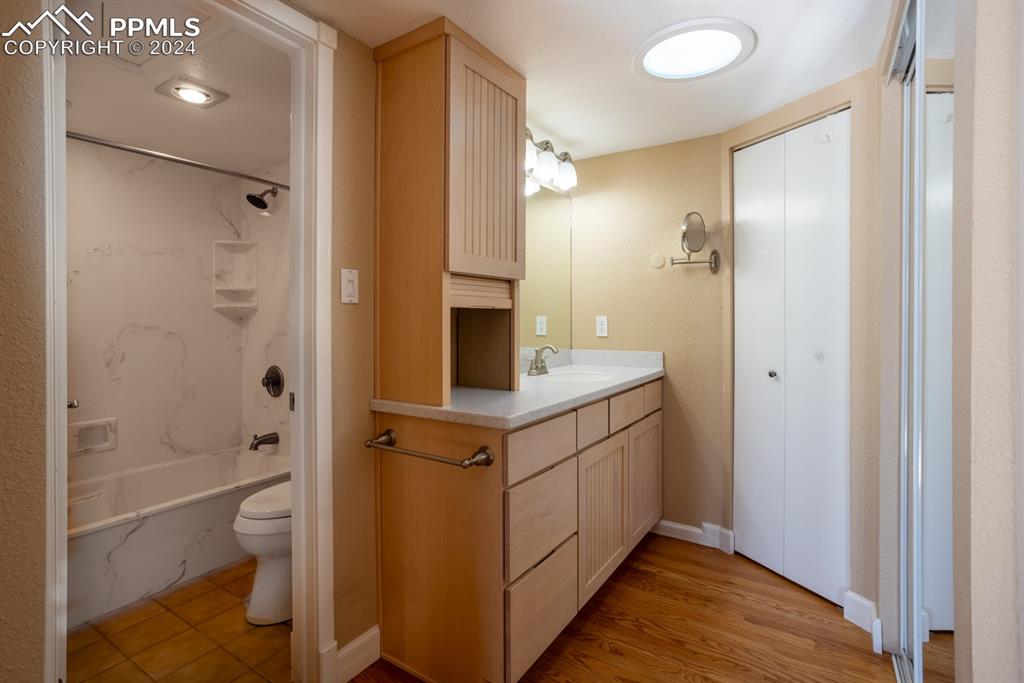 1074 Fontmore Road, Unit C Colorado Springs, CO 80904 - Photo 15 of 30 Full bathroom featuring hardwood / wood-style floor and tile floor, shower / bathtub combination, vanity, and toilet
