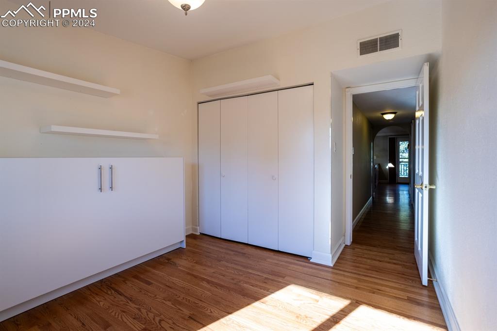 1074 Fontmore Road, Unit C Colorado Springs, CO 80904 - Photo 17 of 30 Second bedroom with Murphy bed, closet, shelves, and hardwood / wood-style floors