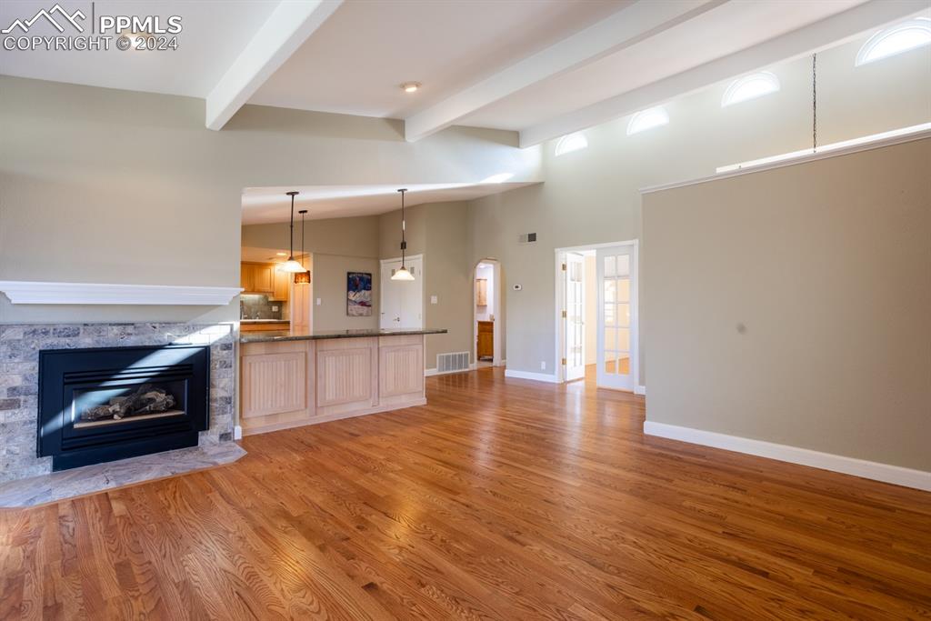 1074 Fontmore Road, Unit C Colorado Springs, CO 80904 - Photo 7 of 30 Living room with high vaulted ceiling, beamed ceiling, hardwood / wood-style flooring, and a fireplace