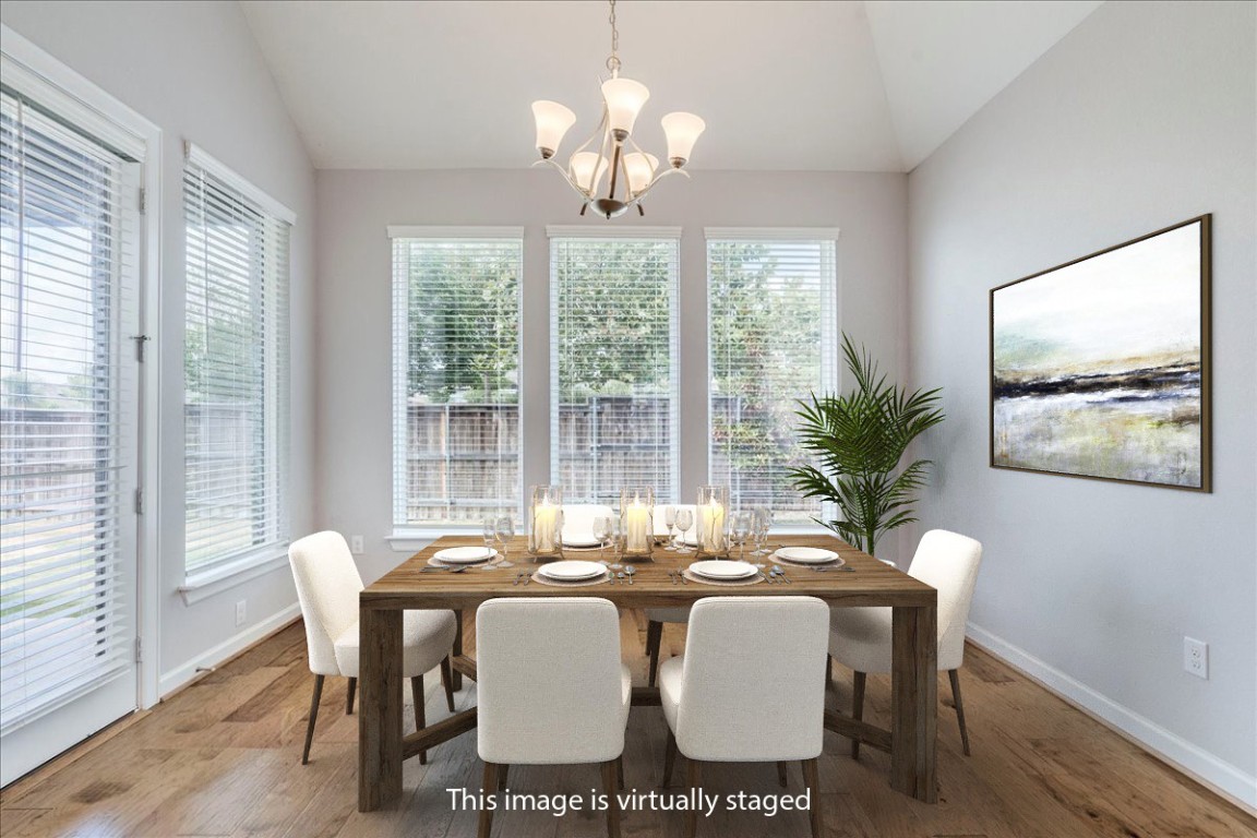 584 Baretta Loop Buda, TX 78610 - Photo 10 of 37 Dining space with vaulted ceiling, wood finished floors, and a chandelier