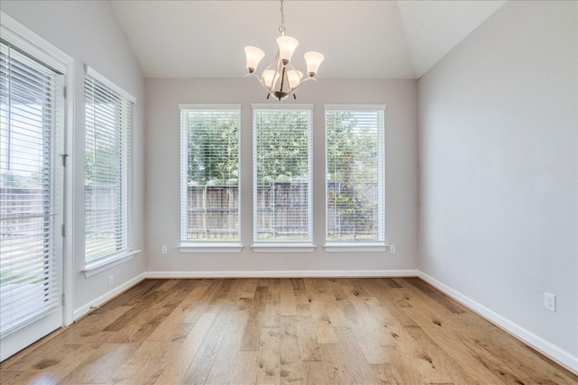 584 Baretta Loop Buda, TX 78610 - Photo 11 of 37 Unfurnished dining area featuring lofted ceiling, a chandelier, and light wood finished floors