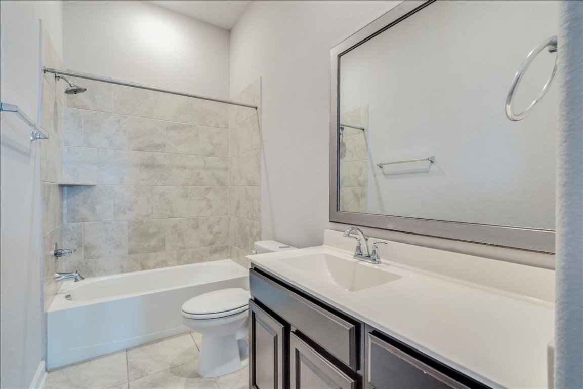 584 Baretta Loop Buda, TX 78610 - Photo 21 of 37 Full bath with shower / bathtub combination, vanity, and light tile patterned flooring