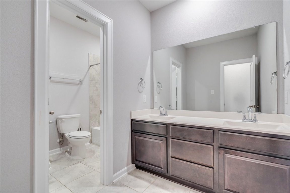 584 Baretta Loop Buda, TX 78610 - Photo 26 of 37 Bathroom with double vanity, light tile patterned floors, and shower / washtub combination