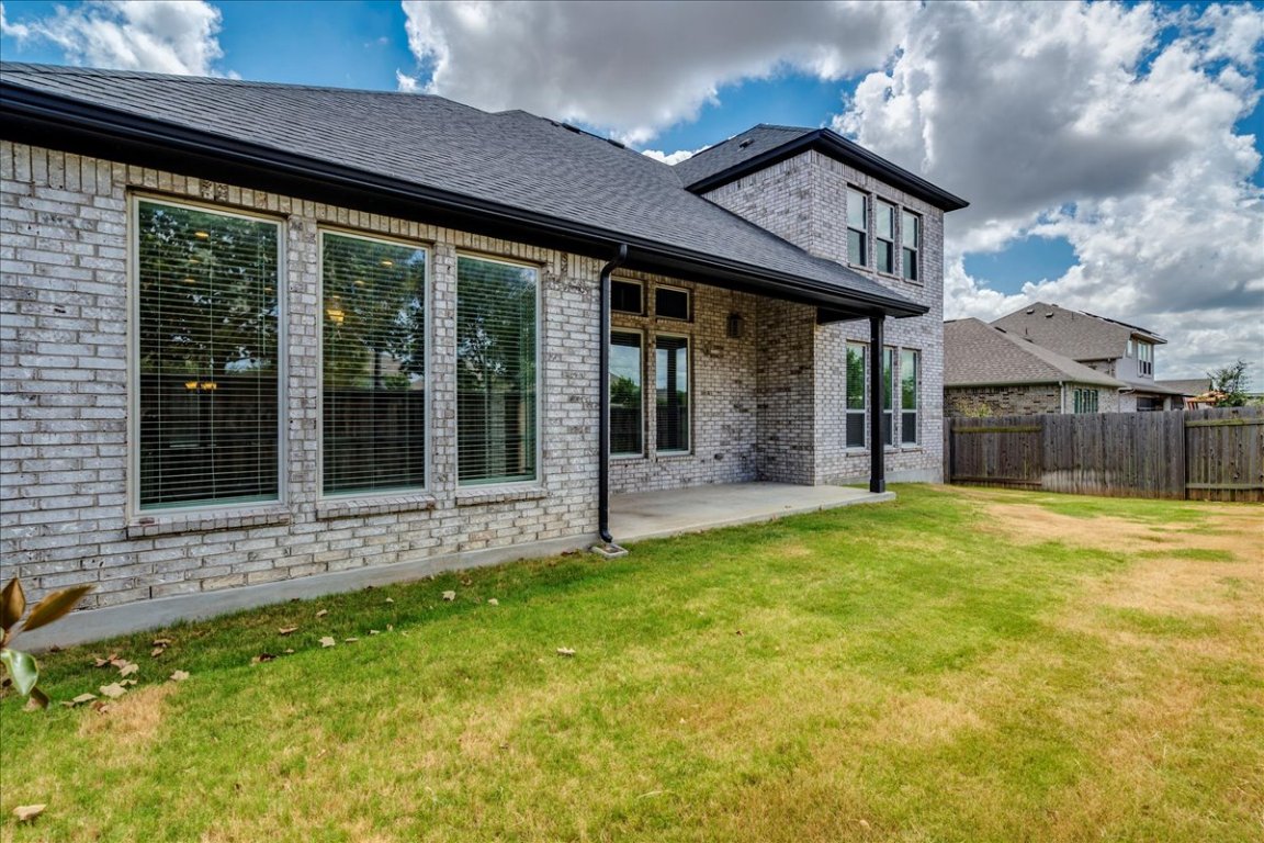 584 Baretta Loop Buda, TX 78610 - Photo 30 of 37 Back of house featuring brick siding, a patio, and roof with shingles