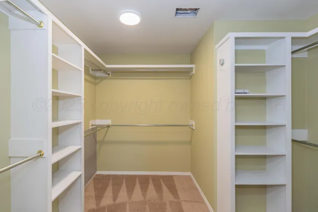 a view of walk in closet with empty racks