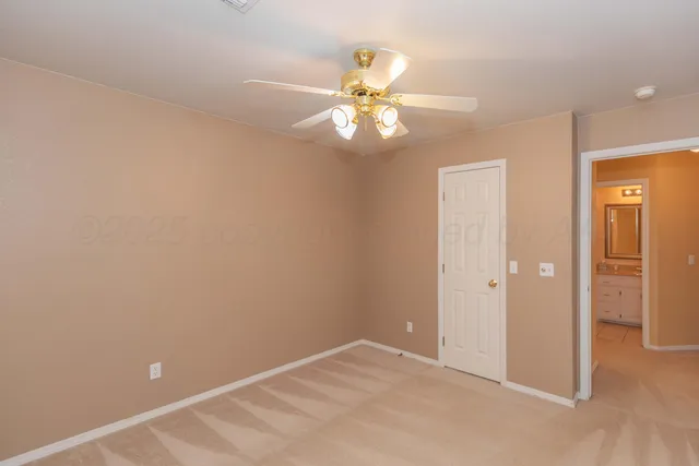 an empty room with a fan and a fan